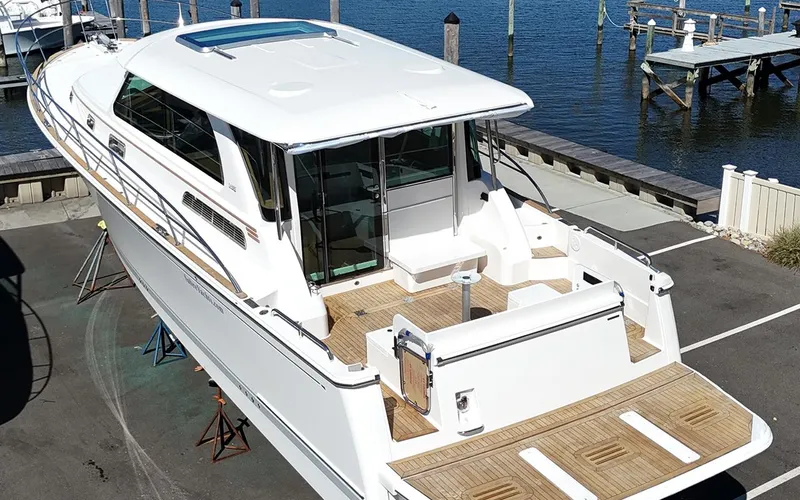 Slide: The Image of 2025 Sabre 45 Salon Express yacht docked, showcasing sleek design and spacious deck. - 12