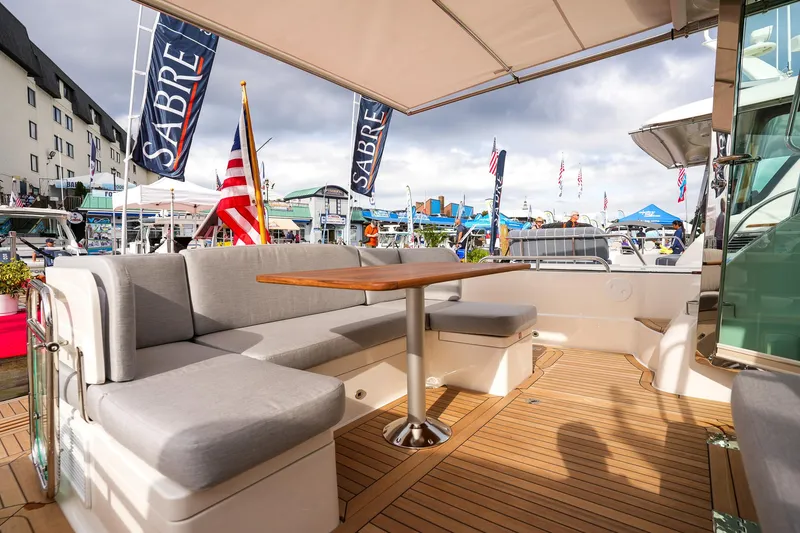 Slide: The Image of Luxurious 2025 Sabre 45 Salon Express yacht with elegant outdoor seating and wooden deck. - 18