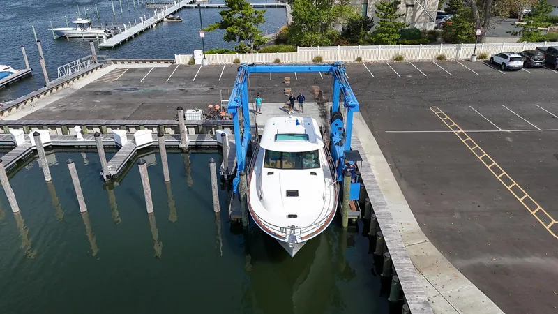 Slide: The Image of 2025 Sabre 45 Salon Express being lifted at a marina dock. - 9