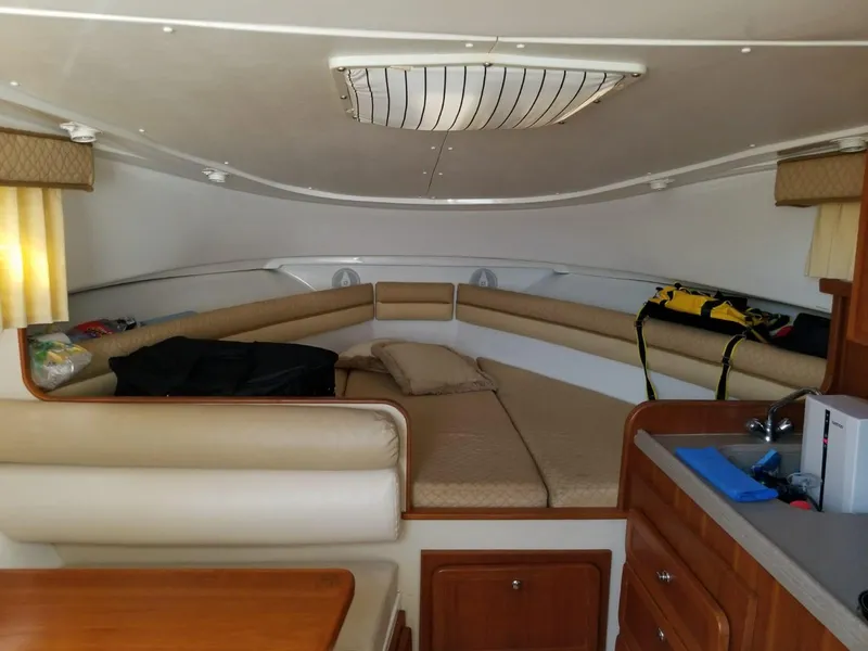 Slide: The Image of Interior cabin of a 2006 Stamas 320 Express boat, featuring cozy seating and a compact kitchenette. - 19