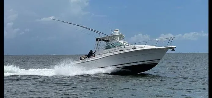 Slide: The Image of 2006 Stamas 320 Express boat cruising on open water under a clear sky. - 6