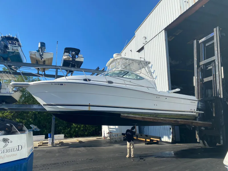 Slide: The Image of 2006 Stamas 320 Express boat lifted near a large warehouse. - 9