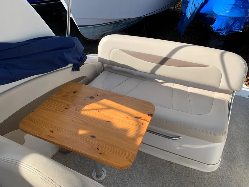 Slide: The Image of 2006 Chaparral 276 Signature boat interior with wooden table and beige seating. - 11