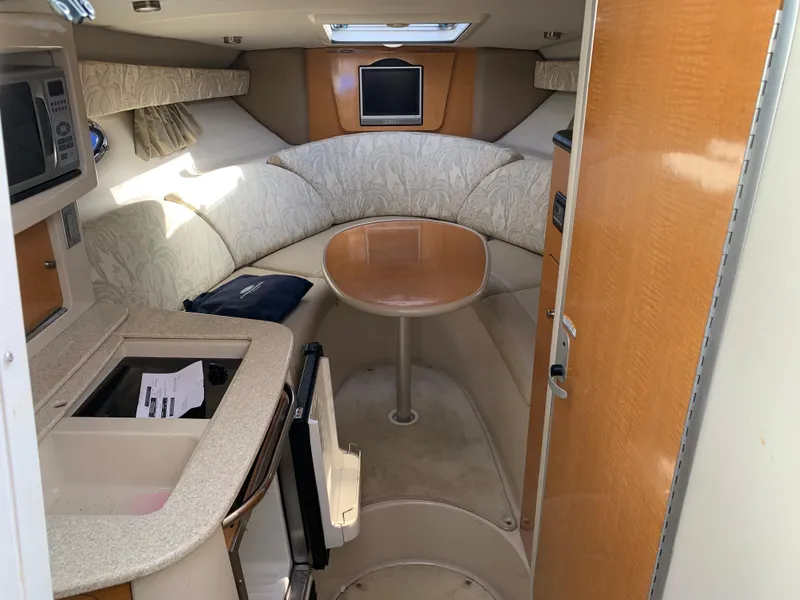 Slide: The Image of 2006 Chaparral 276 Signature cabin interior with kitchenette, seating area, and table. - 12
