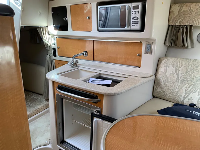 Slide: The Image of 2006 Chaparral 276 Signature boat interior with kitchenette, microwave, sink, and mini-fridge. - 14