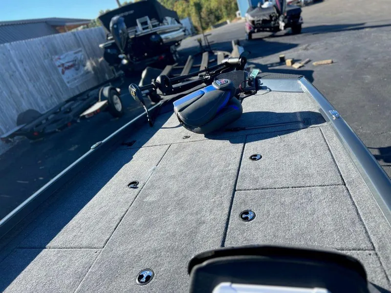 Slide: The Image of 2023 Ranger RT198P boat deck with fishing equipment in a parking area. - 2