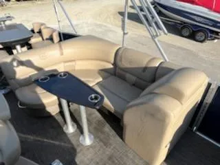 Slide: The Image of 2019 Godfrey 259CBD pontoon boat interior with beige seating and black table. - 12