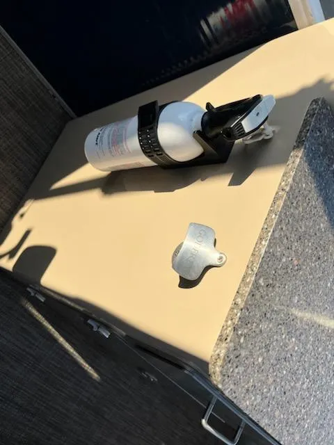 Slide: The Image of Fire extinguisher mounted on a 2019 Godfrey 259CBD boat countertop. - 16