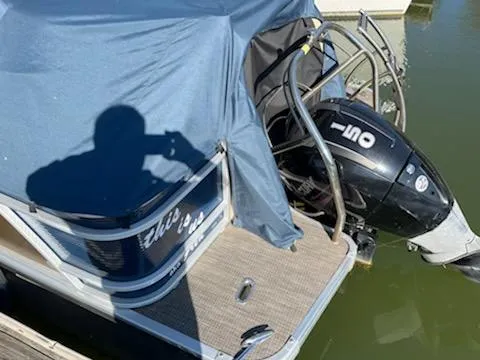 Slide: The Image of Covered 2019 Godfrey 259CBD boat with outboard motor on water. - 2