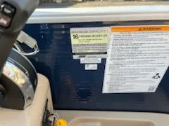 Slide: The Image of 2019 Godfrey 259CBD boat capacity and warning labels near steering wheel. - 8
