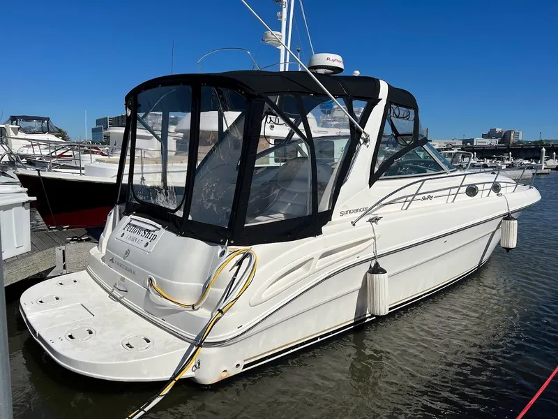 The Image of 2000 Sea Ray 34 DA boat docked in marina, featuring sleek design and black canopy. - 0