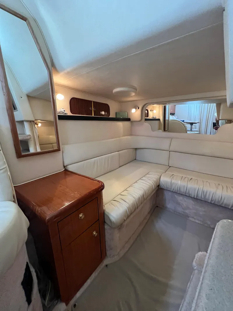 Slide: The Image of Interior of 2000 Sea Ray 34 DA yacht with cozy seating and wooden cabinetry. - 34