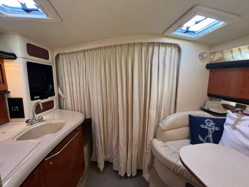 Slide: The Image of Interior of 2000 Sea Ray 34 DA yacht with cozy seating and kitchenette. - 35