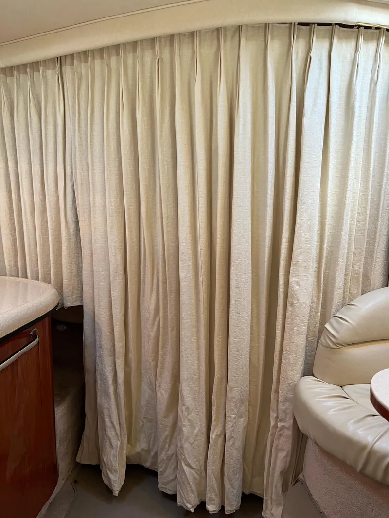 Slide: The Image of Interior of 2000 Sea Ray 34 DA with cream curtains and leather seating. - 36