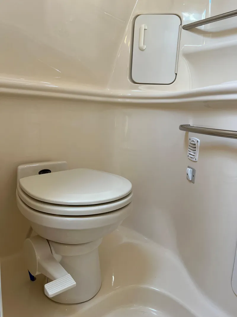 Slide: The Image of 2000 Sea Ray 34 DA boat bathroom with toilet and storage compartment. - 38