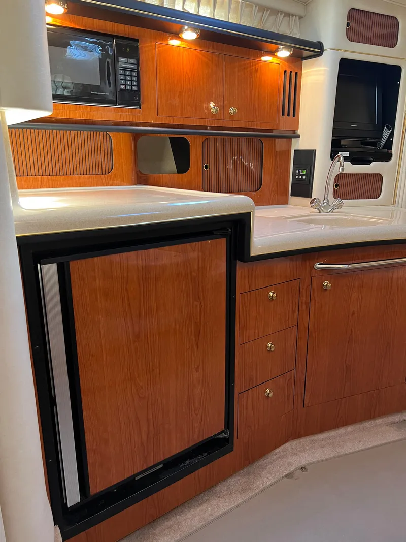 Slide: The Image of 2000 Sea Ray 34 DA yacht kitchen with wood cabinets and modern appliances. - 45