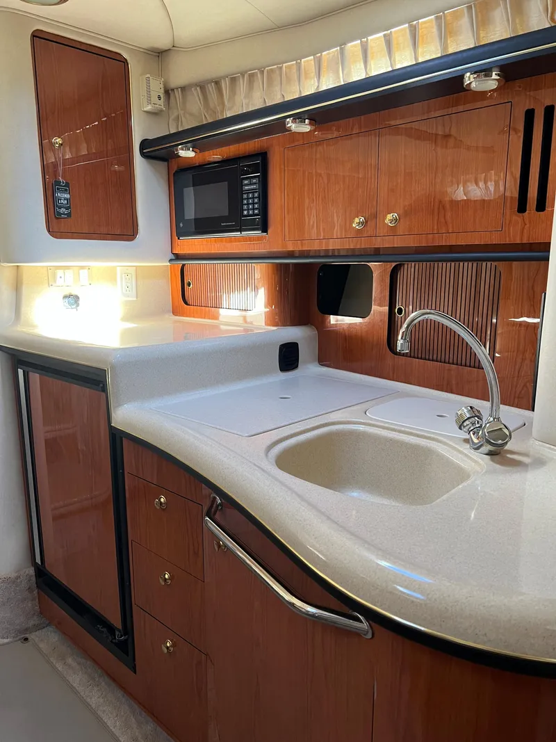 Slide: The Image of 2000 Sea Ray 34 DA yacht kitchen with wood cabinetry and modern appliances. - 47
