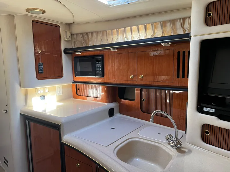 Slide: The Image of Luxurious 2000 Sea Ray 34 DA yacht kitchen with wood cabinetry and modern appliances. - 49