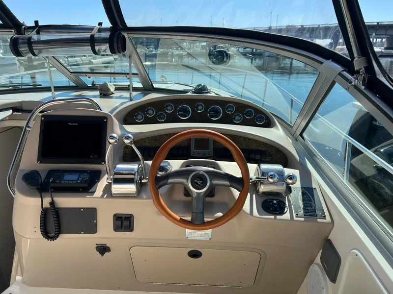 Slide: The Image of 2000 Sea Ray 34 DA boat helm with wood steering wheel and modern controls. - 5
