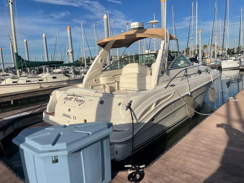 Slide: The Image of 2002 Sea Ray 340 Sundancer docked at marina, clear sky, calm waters. - 0
