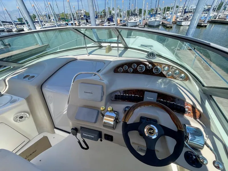 Slide: The Image of Helm of 2002 Sea Ray 340 Sundancer at marina, showcasing steering wheel and control panel. - 19