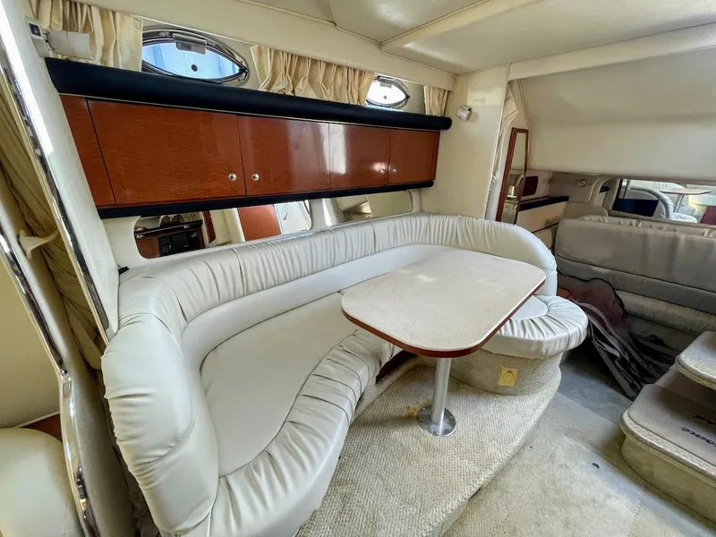 Slide: The Image of 2002 Sea Ray 340 Sundancer interior with curved seating and dining table. - 30