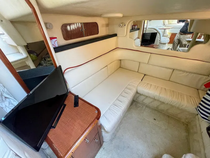 Slide: The Image of Interior of 2002 Sea Ray 340 Sundancer with beige seating and mounted TV. - 33