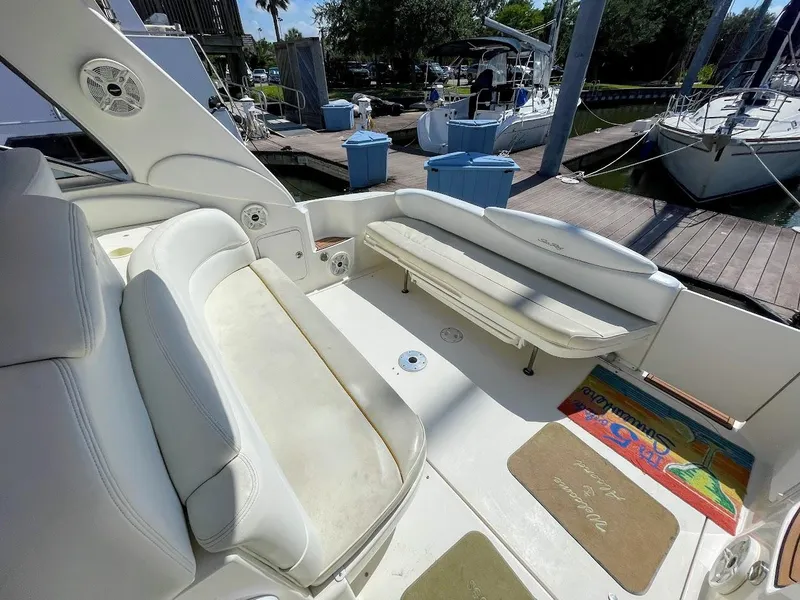 Slide: The Image of 2002 Sea Ray 340 Sundancer boat interior with white seating at marina. - 35