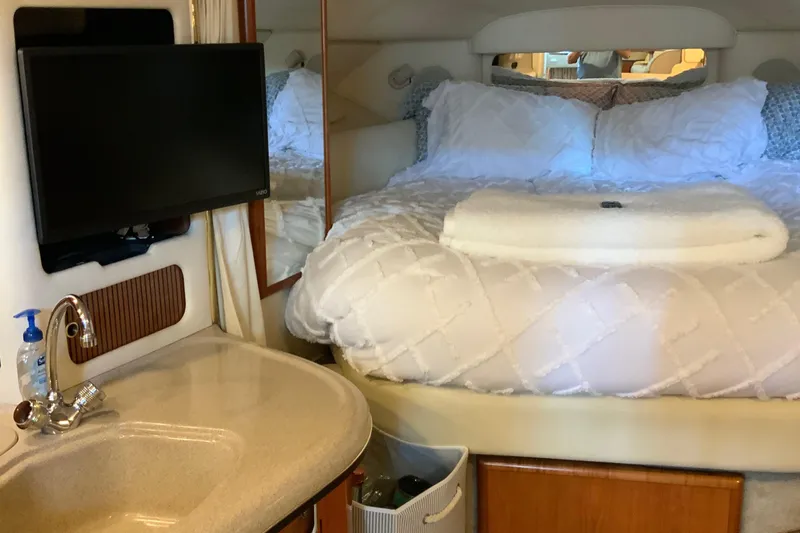 Slide: The Image of 2000 Sea Ray Sundancer cabin interior with bed, TV, and sink. - 20