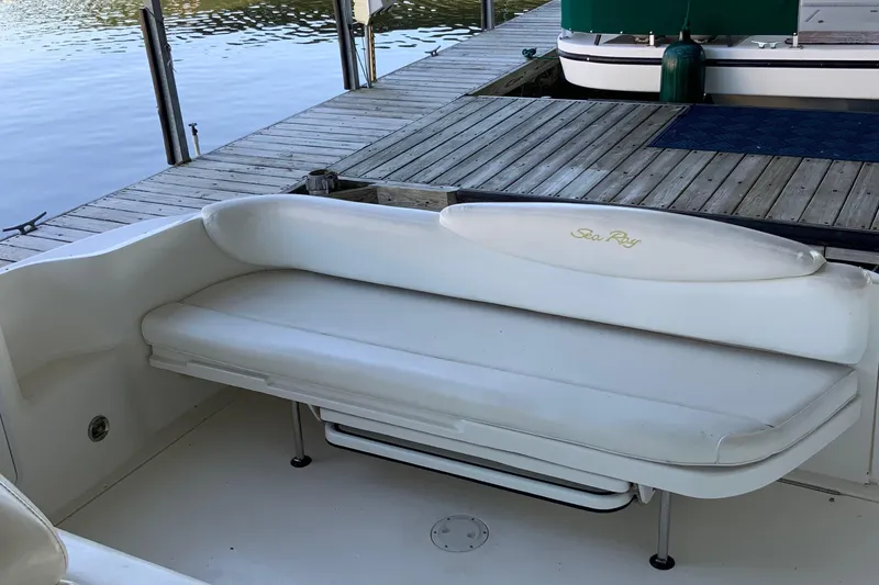 Slide: The Image of White seating area on a 2000 Sea Ray Sundancer boat docked by the water. - 7