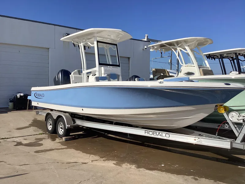 The Image of 2023 Robalo 246 Cayman boat on a trailer, parked outdoors. - 0