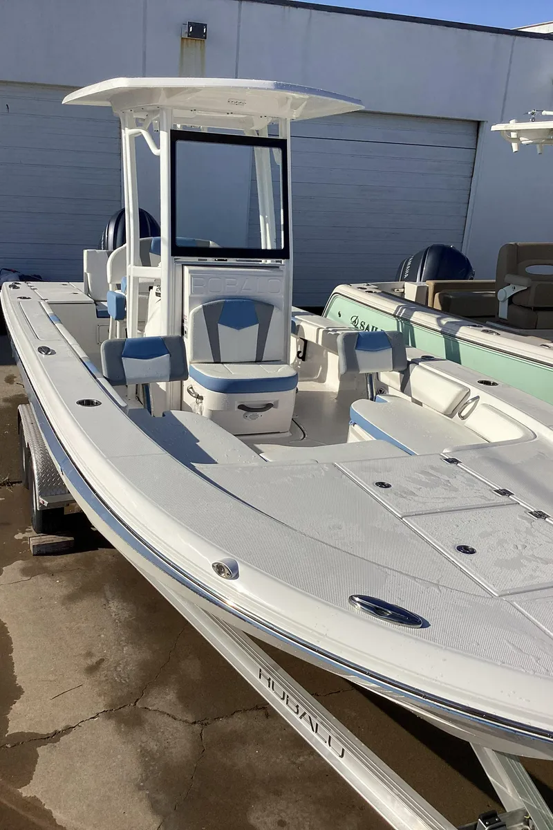 Slide: The Image of 2023 Robalo 246 Cayman boat with T-top and seating, docked on a trailer. - 10
