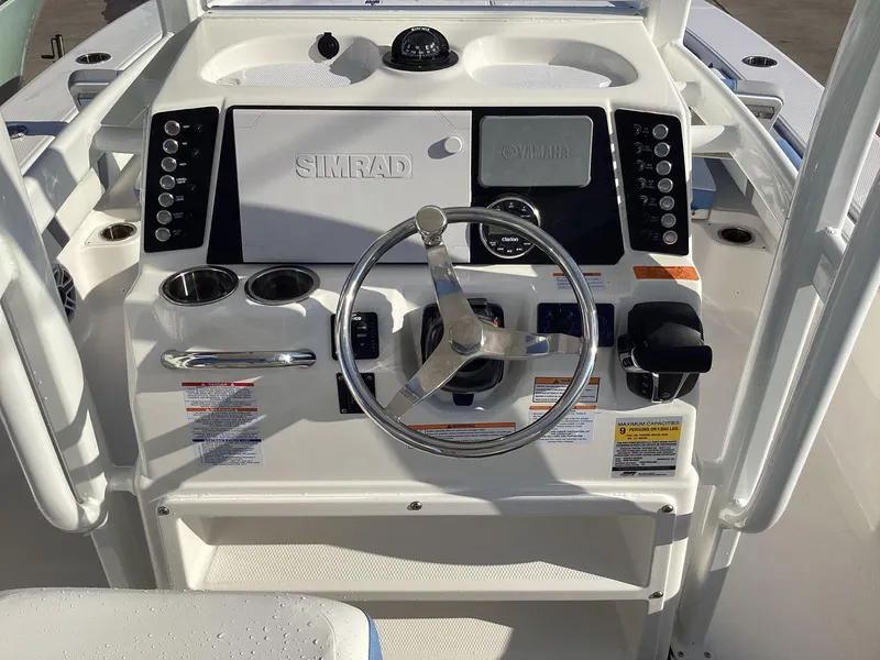 Slide: The Image of 2023 Robalo 246 Cayman boat helm with Simrad electronics and stainless steel steering wheel. - 4