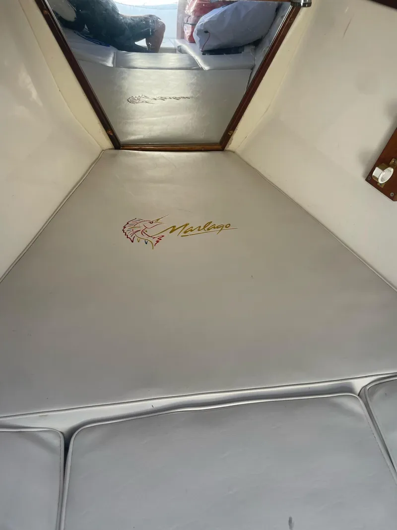 Slide: The Image of Interior of a 2005 Marlago 35 boat with cushioned flooring. - 17