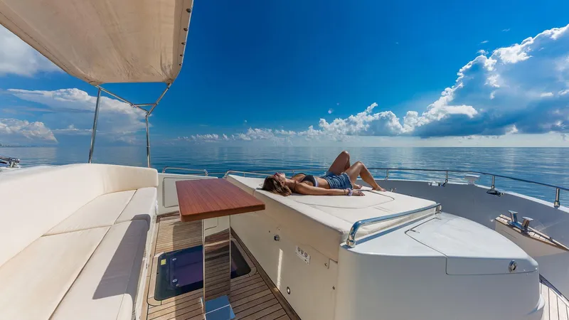 Slide: The Image of Woman relaxing on 2015 Dominator 800 yacht under clear blue sky. - 14