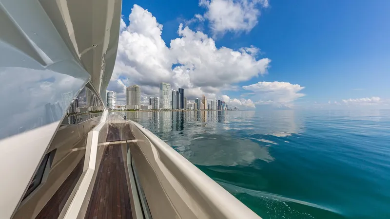 Slide: The Image of Luxury yacht Dominator 800 cruising near city skyline, clear blue skies, and calm waters. - 15