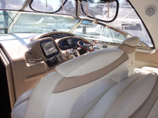 Slide: The Image of Interior of 1999 Sea Ray 410 Express Cruiser with beige seating and modern dashboard. - 12