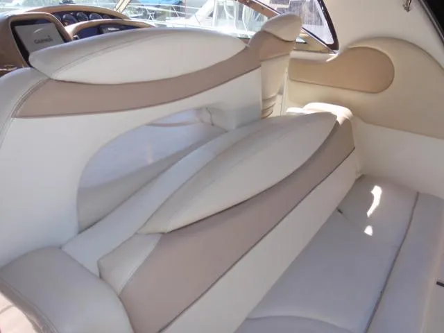 Slide: The Image of Interior seating of 1999 Sea Ray 410 Express Cruiser, featuring beige and white upholstery. - 14