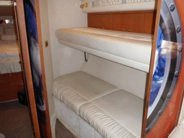 Slide: The Image of 1999 Sea Ray 410 Express Cruiser interior with bunk beds and porthole. - 15
