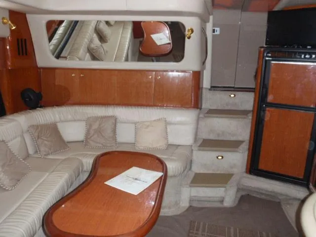 Slide: The Image of Luxurious interior of 1999 Sea Ray 410 Express Cruiser with plush seating and wooden accents. - 16