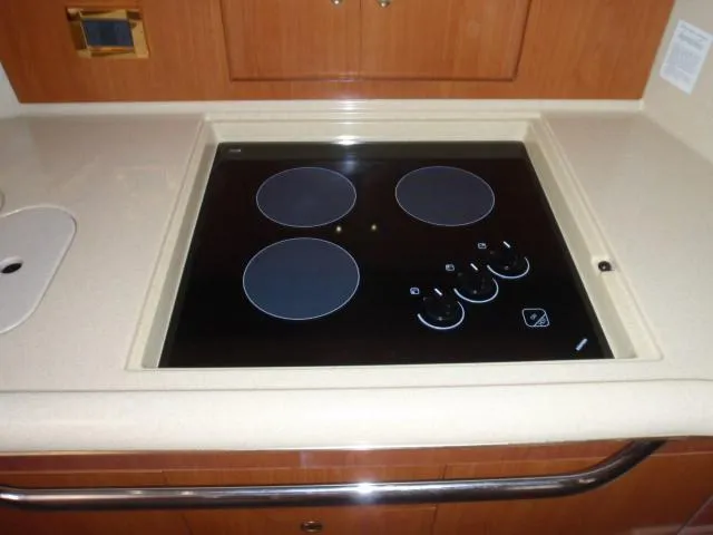 Slide: The Image of 1999 Sea Ray 410 Express Cruiser kitchen with electric stovetop. - 18