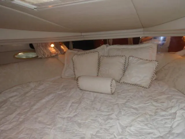 Slide: The Image of Luxurious cabin interior of 1999 Sea Ray 410 Express Cruiser with plush bedding. - 25