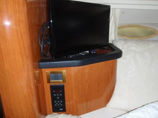 Slide: The Image of 1999 Sea Ray 410 Express Cruiser interior with mounted TV and control panel. - 26