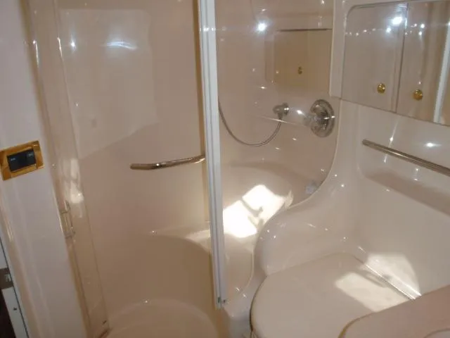 Slide: The Image of 1999 Sea Ray 410 Express Cruiser bathroom with shower and storage cabinets. - 27