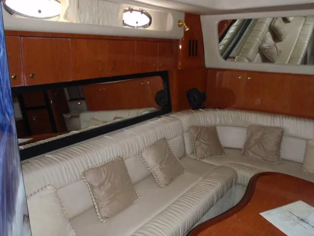 Slide: The Image of Interior of 1999 Sea Ray 410 Express Cruiser with beige seating and wooden accents. - 29