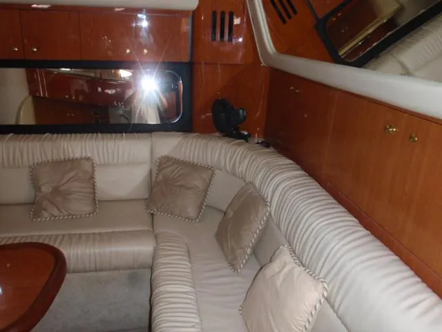 Slide: The Image of Luxurious interior of 1999 Sea Ray 410 Express Cruiser with plush seating and wood accents. - 30