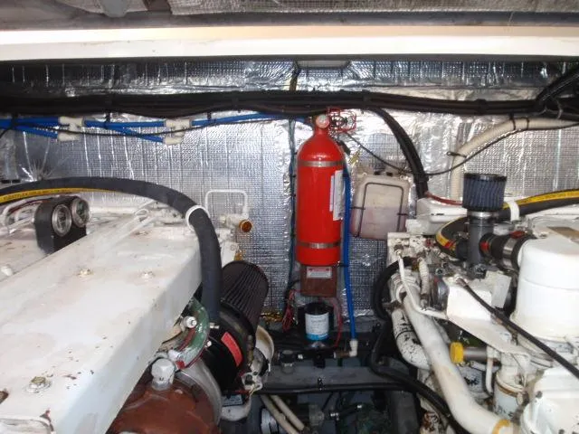 Slide: The Image of Engine room of 1999 Sea Ray 410 Express Cruiser with fire extinguisher and wiring. - 34