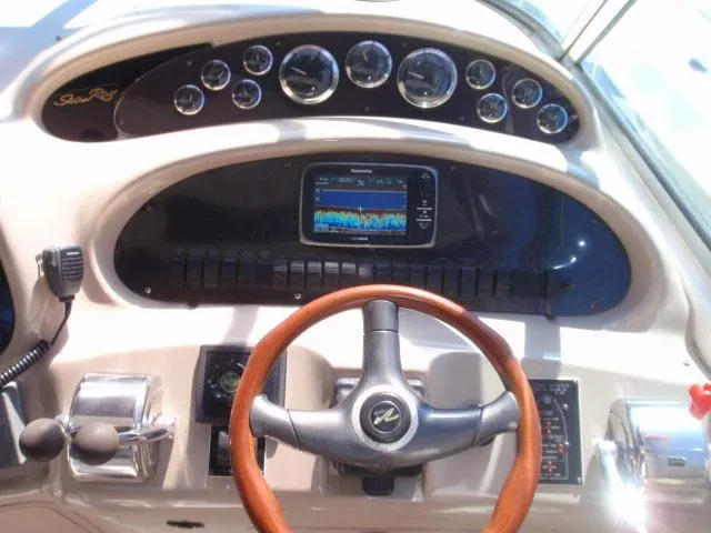 Slide: The Image of 1999 Sea Ray 410 Express Cruiser docked, covered, surrounded by trees and parked cars. - 4