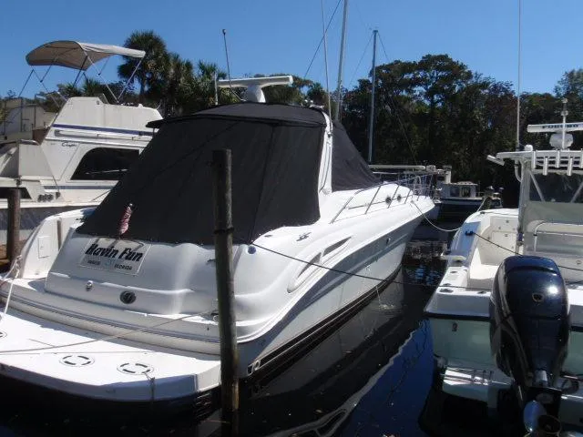 Slide: The Image of 1999 Sea Ray 410 Express Cruiser docked in marina, covered with black tarp. - 47