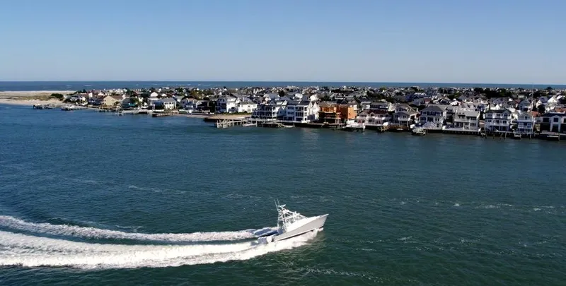 Slide: The Image of A Conch 47 boat cruising near a coastal town, 2021. - 11